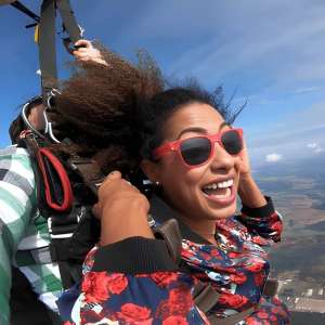Woman smiling with sunglasses during tandem skydive over the Nashville Tennessee countryside